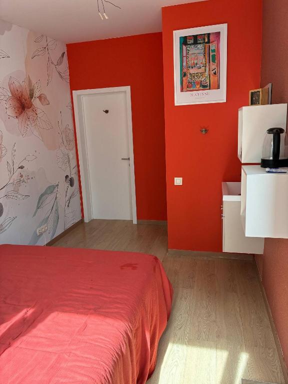 a bedroom with red walls and a bed in it at Tastefully-decorated bedroom with garden access in Brussels