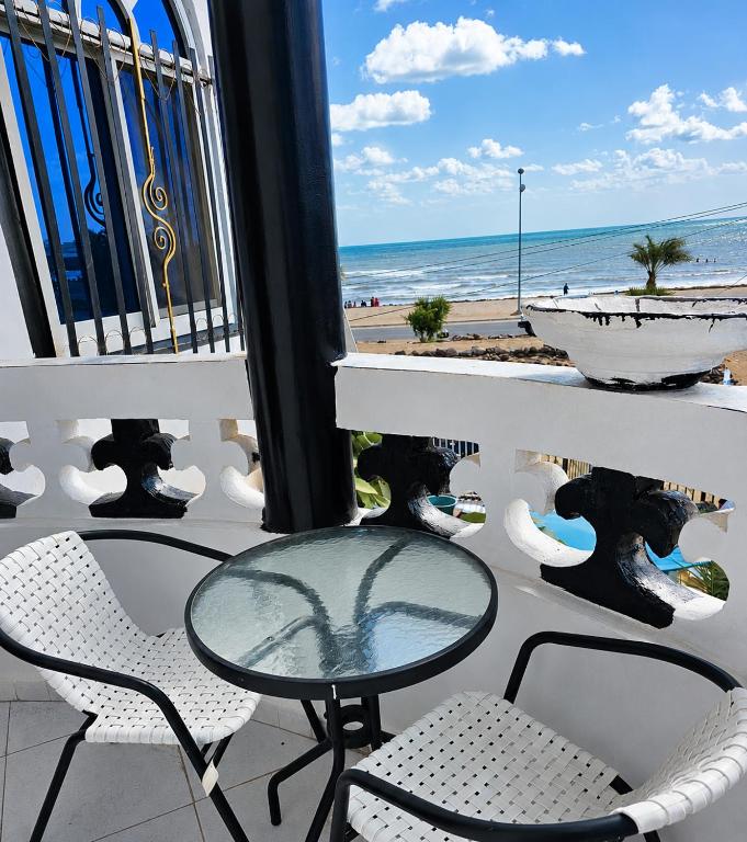 a table and chairs on a balcony with the beach at Brise de mer L'écume in La Plaine