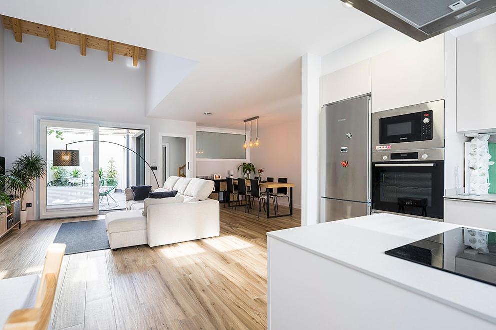 a kitchen and living room with white furniture and a table at CasaGurutze in Elizalde