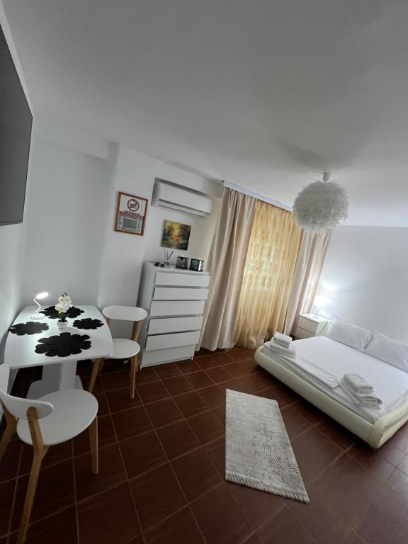 a bedroom with a bed and a table and chairs at Studio Callatis Mangalia in Mangalia