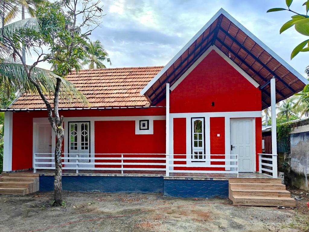 a red house with a red roof at Heinrich Wolfi Private Cotege in Pattiyūrgrāmam