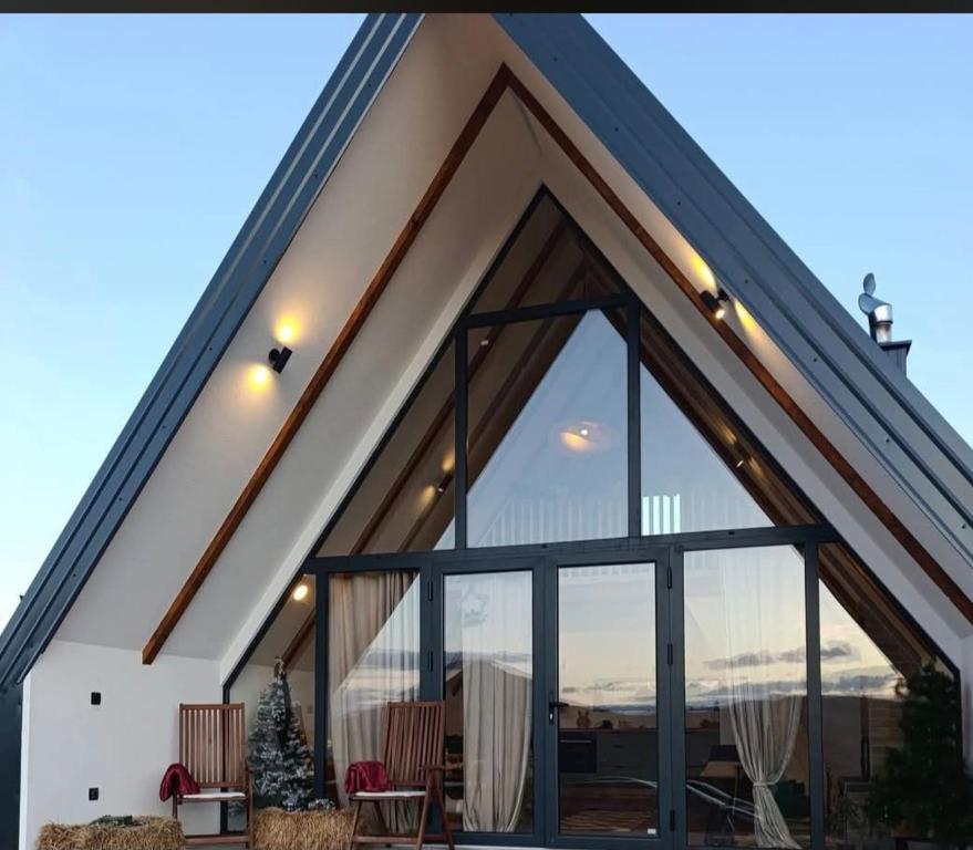 a house with large glass windows and a roof at Ninina koliba-vikendica Manjaca in Hiseti