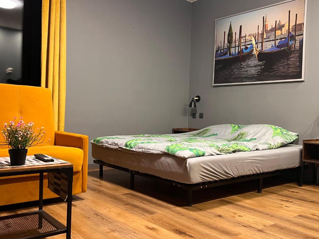 a bedroom with a bed and a couch and a table at Stacja Nałęczów 2 in Nałęczów
