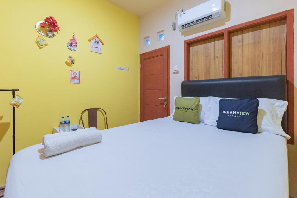 a bedroom with a white bed with pillows on it at Urbanview Hotel Sany Cirebon in Tangkil