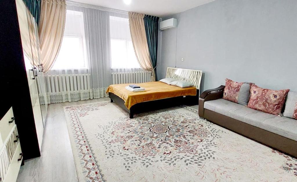 a living room with a couch and a table at ЖК Куралай in Qyzylorda