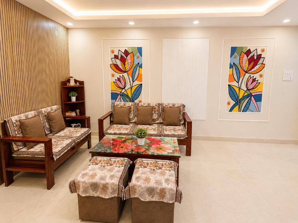 a living room with two chairs and a table at Petal & Peak Stays in Rājpur