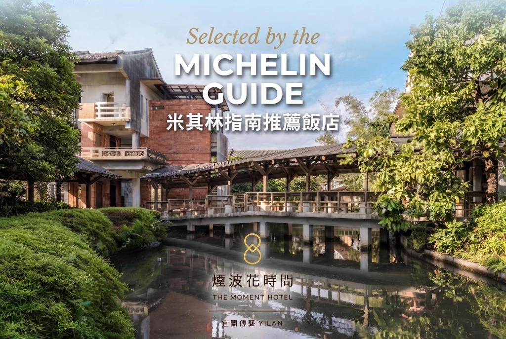 a building with a river in front of it at The Moment Hotel Yilan by Lakeshore in Wujie