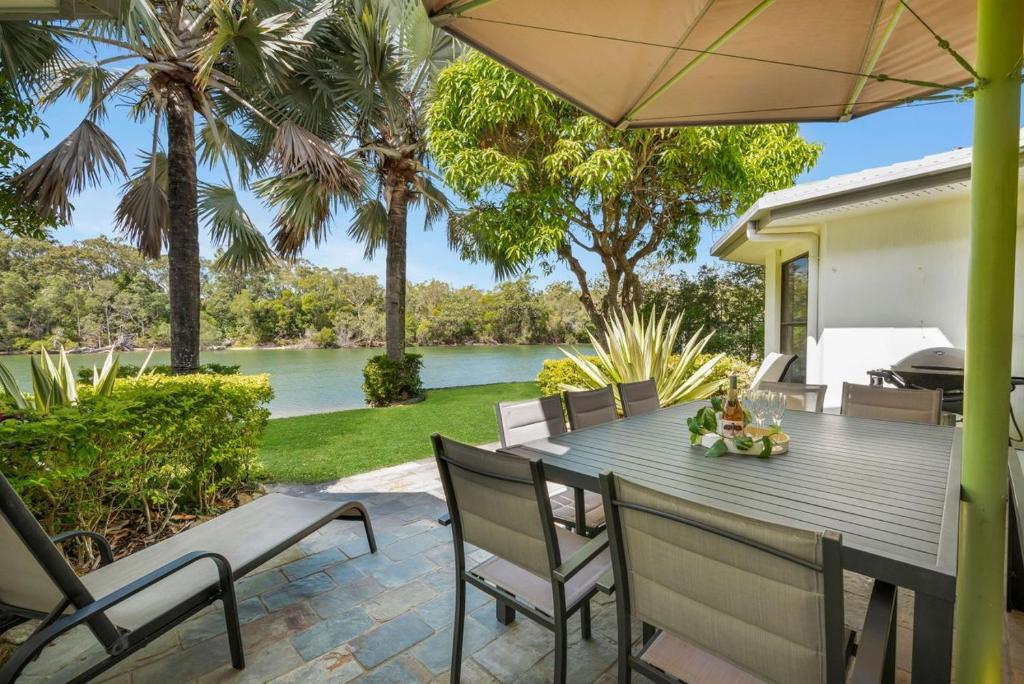 a table with chairs and an umbrella on a patio at Wyuna Drive 53 in Noosaville