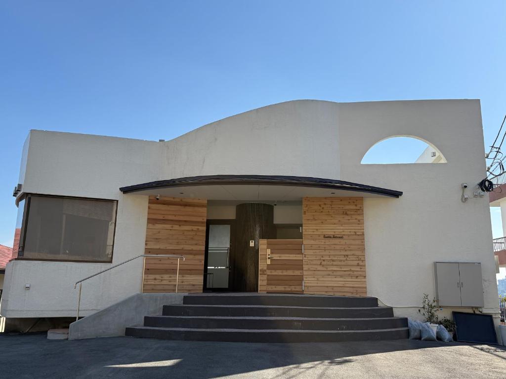a building with stairs leading to a door at Rustic Retreat リトリート真鶴 in Manazuru