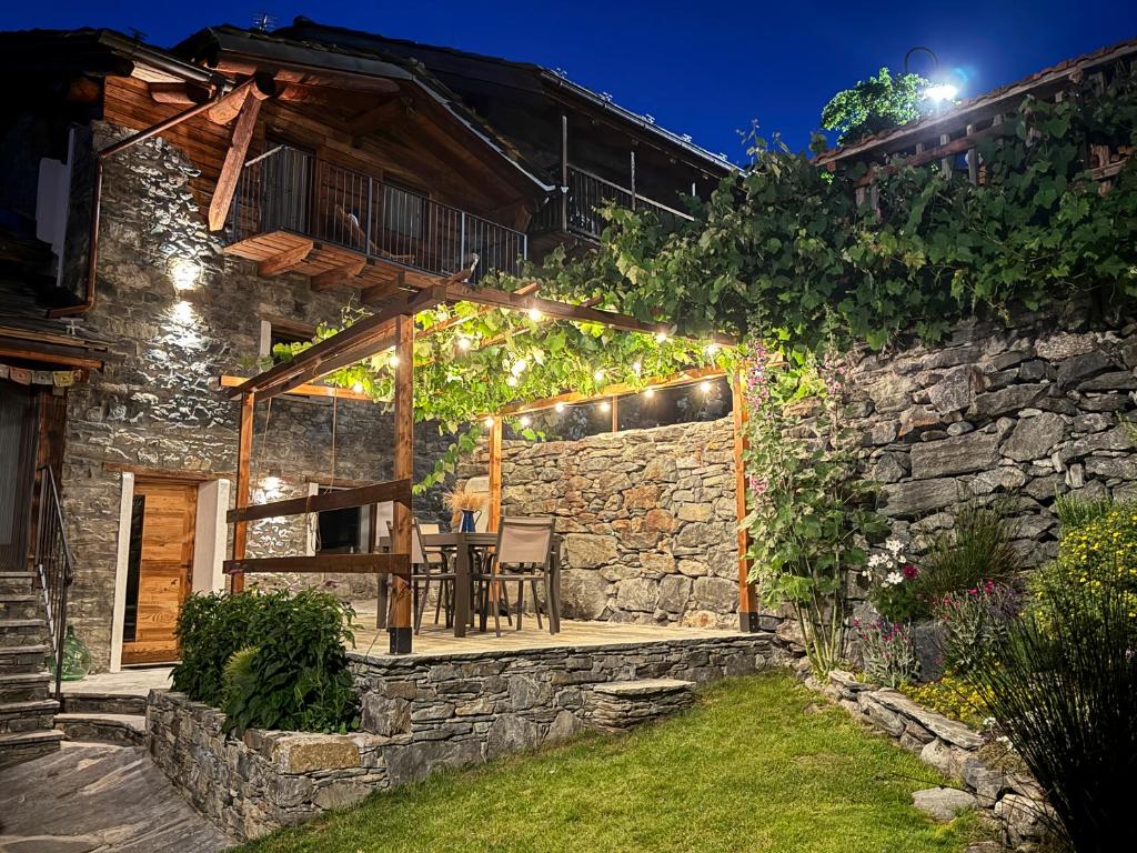 a stone house with a table and chairs on a patio at Little Wild House in Saint Vincent