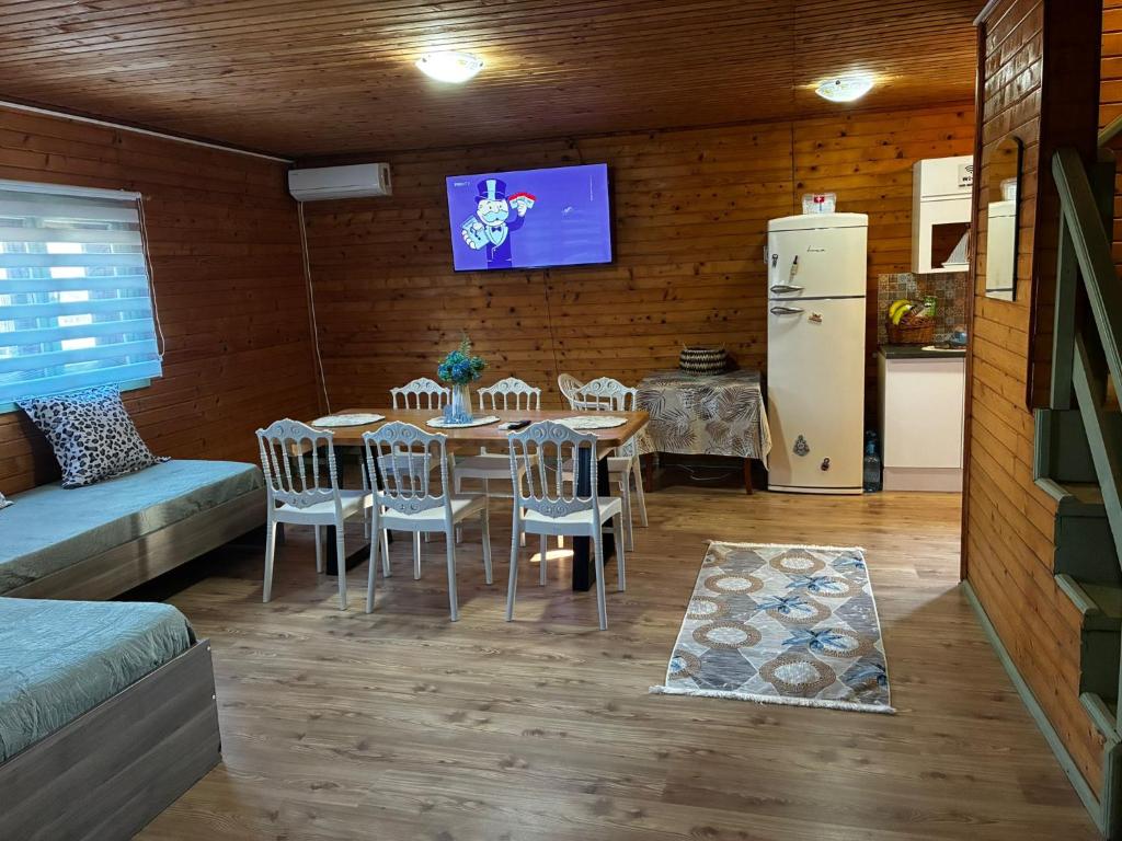 a dining room with a table and chairs and a refrigerator at Casa B&P in Costinesti