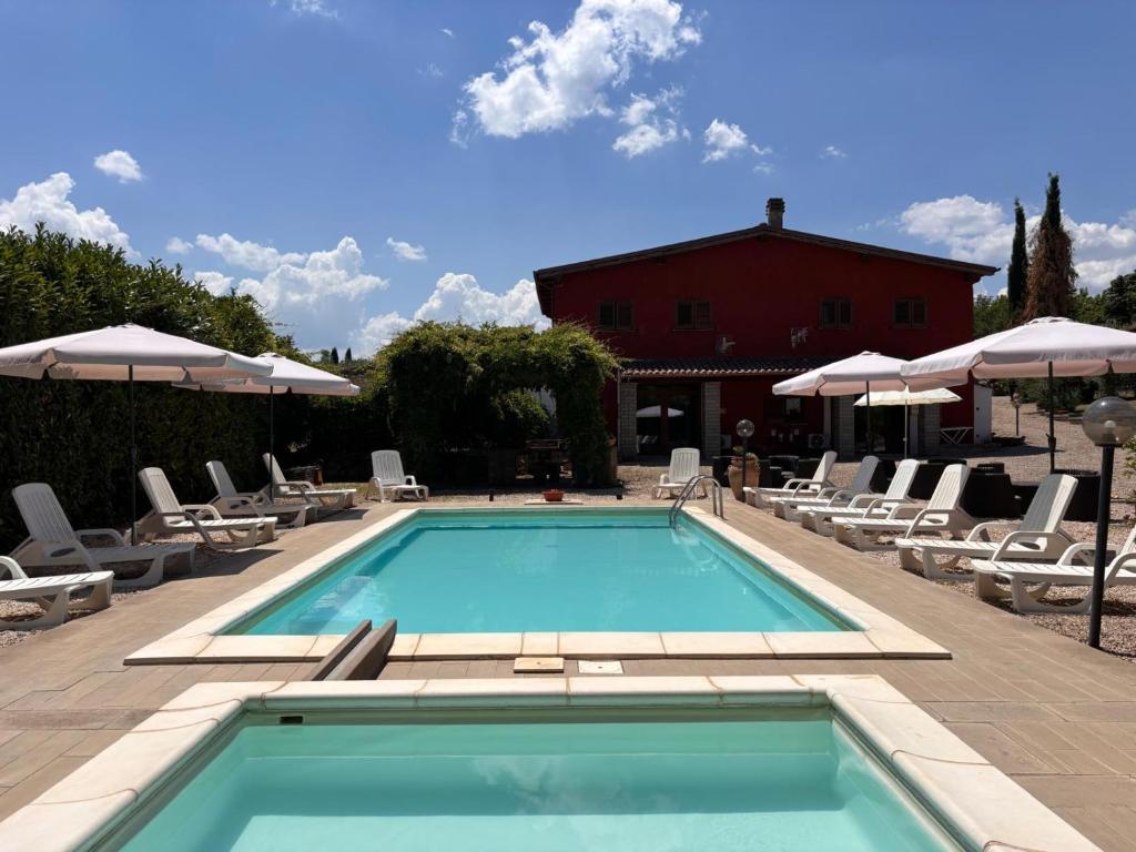 a swimming pool with chairs and umbrellas at CASALE ANTICO SOBBORGO in Vitorchiano