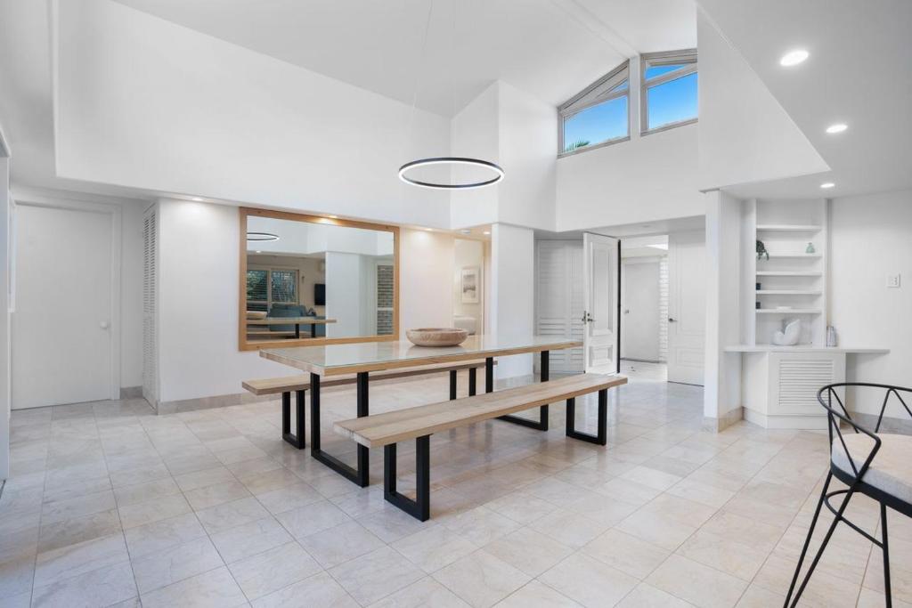 a dining room with a table and a bench at Witta Circle 24 in Noosa Heads