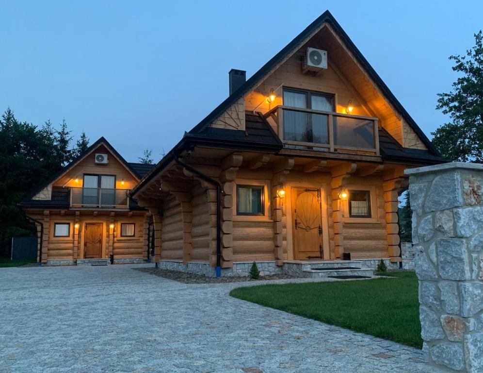 a log home with a stone driveway at Bałtowska Osada in Bałtów
