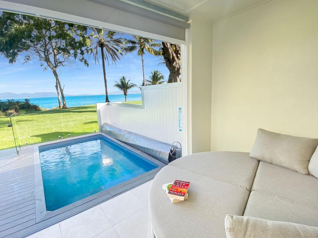 a living room with a couch and a swimming pool at Rock Salt Villa 2 in Picnic Bay