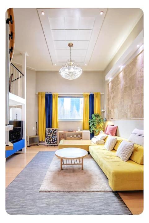 a living room with a yellow couch and a table at Young Stay in Seoul