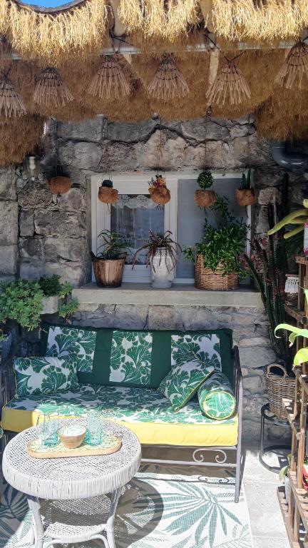 eine Terrasse mit Tisch und Bank mit Pflanzen in der Unterkunft Escapade à 2 in Ruoms