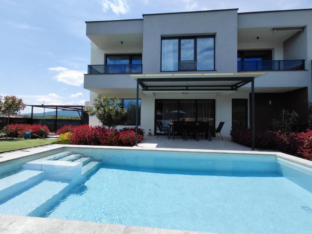a house with a swimming pool in front of a house at Villa Calypso, private pool with heating and salt water in Lozenets