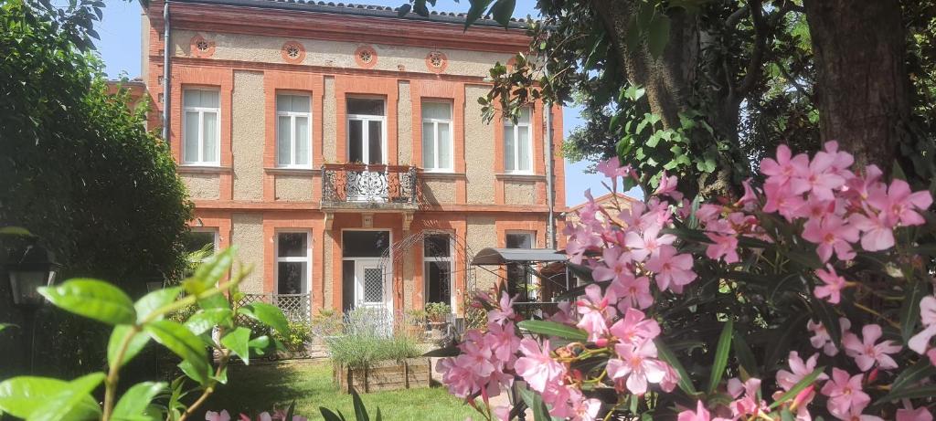 a building with pink flowers in front of it at La Maison du Poelon in Labarthe-sur-Lèze