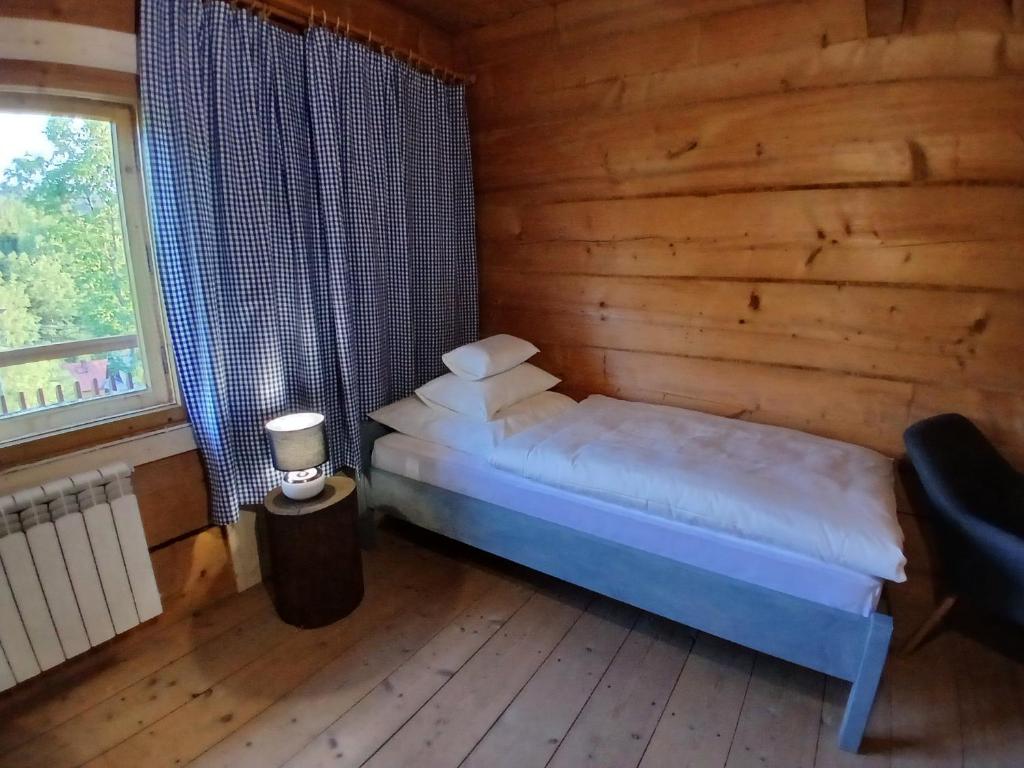a bedroom with a bed in a log cabin at Bauernhaus in Dzianisz