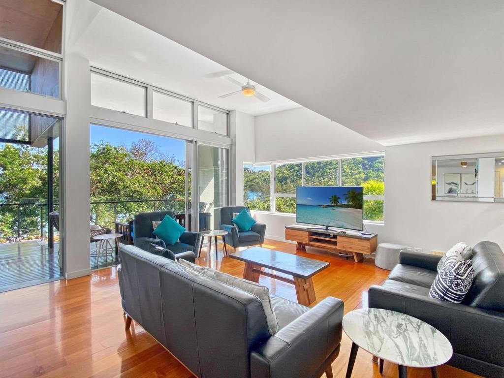 a living room with couches and a television at Maggies Beachfront Apartment 12 in Horseshoe Bay