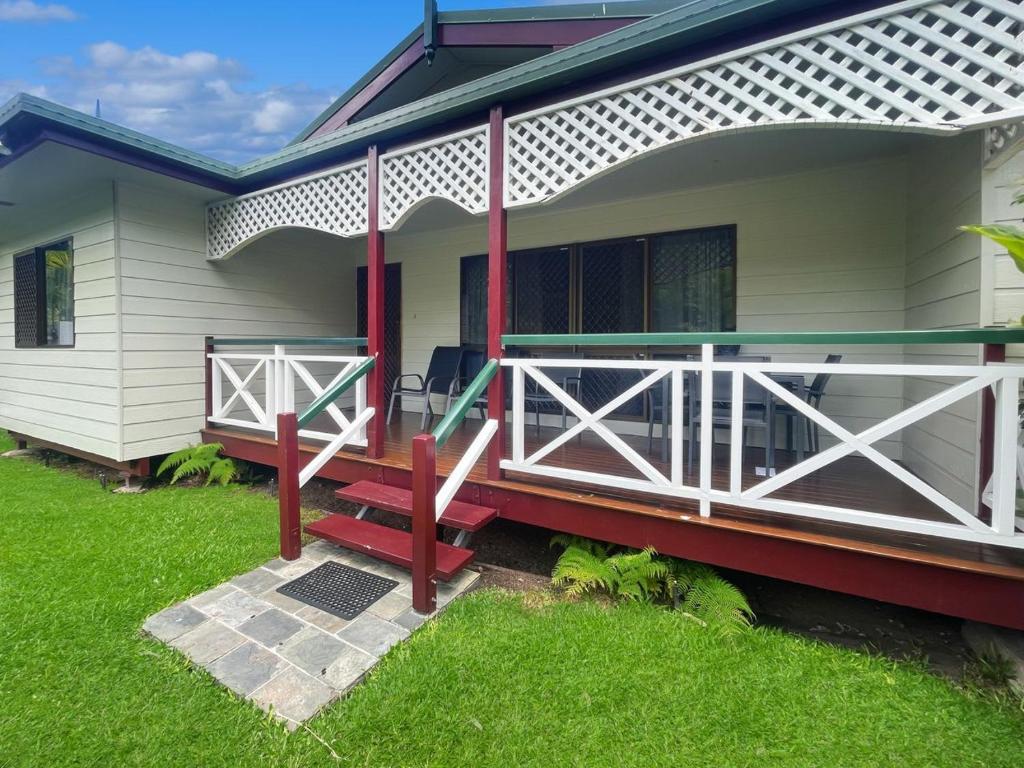 a house with a porch with a red bench on it at Arcadia Gardens in Arcadia