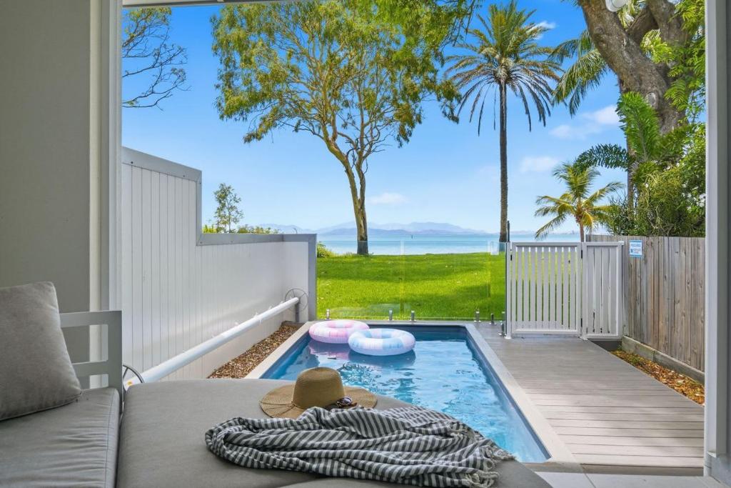 a patio with a swimming pool and a couch at Rock Salt Villa 1 in Picnic Bay