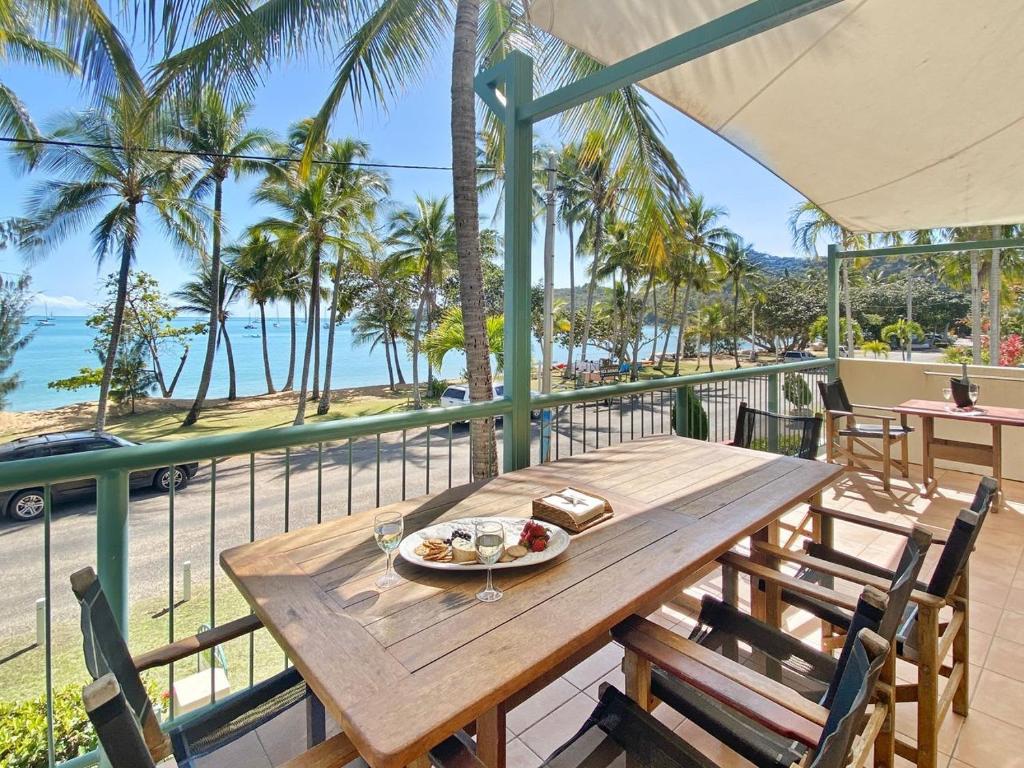 a wooden table with a plate of food on a balcony at Sails on Horseshoe Apartment 4 in Horseshoe Bay