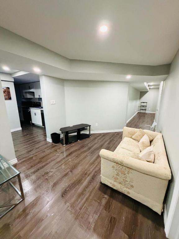 ein Wohnzimmer mit Sofa und Tisch in der Unterkunft Niagara Falls 2 Bedrooms 1 and half washroom Luxury Basement Apartment in Thorold