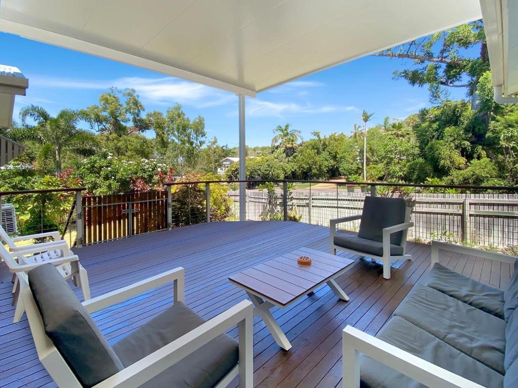 a deck with an umbrella and a table and chairs at Kadani in Picnic Bay