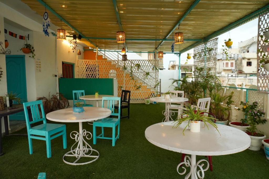 a room with tables and chairs and plants at Hostel Mama in Udaipur