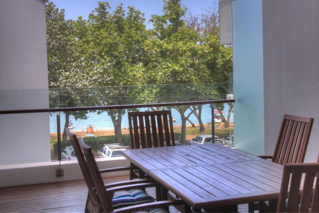 a table and chairs on a balcony with a view of the ocean at Maggies Beachfront Apartment 6 in Horseshoe Bay