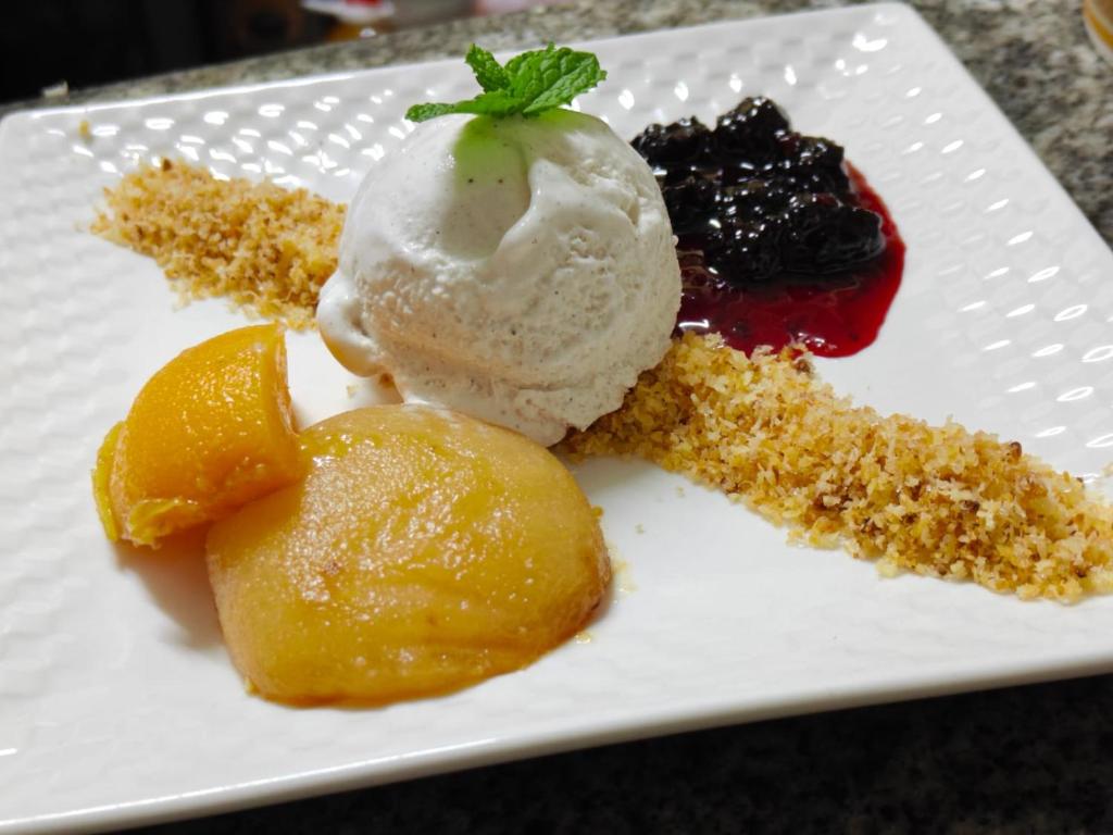 a white plate with ice cream and fruit on it at Cotton Beach Holidays in Saint Francois