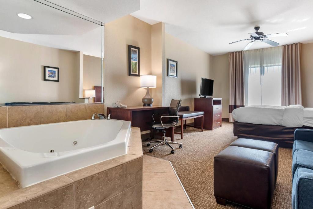 a hotel room with a tub and a bed at Comfort Inn & Suites Clinton - Jackson West in Clinton