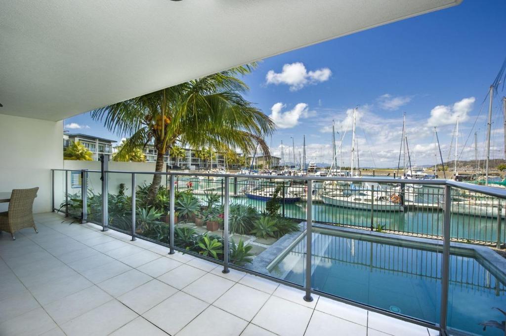 a balcony with a view of a marina at Blue on Blue Apartment 912 in Nelly Bay