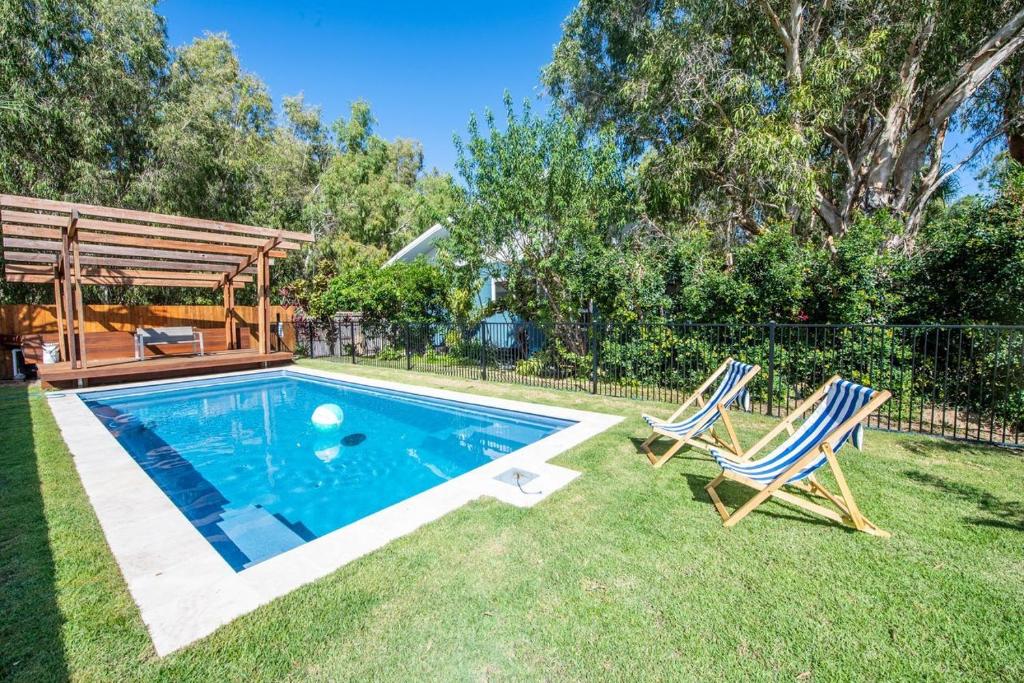 a swimming pool with two chairs and a gazebo at The Wave in Horseshoe Bay