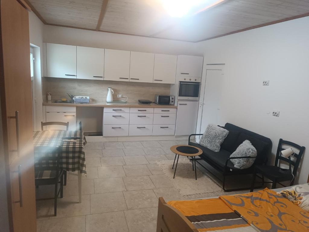 a kitchen with white cabinets and a table and chairs at Imanje Mihailovic 2 in Pružatovac