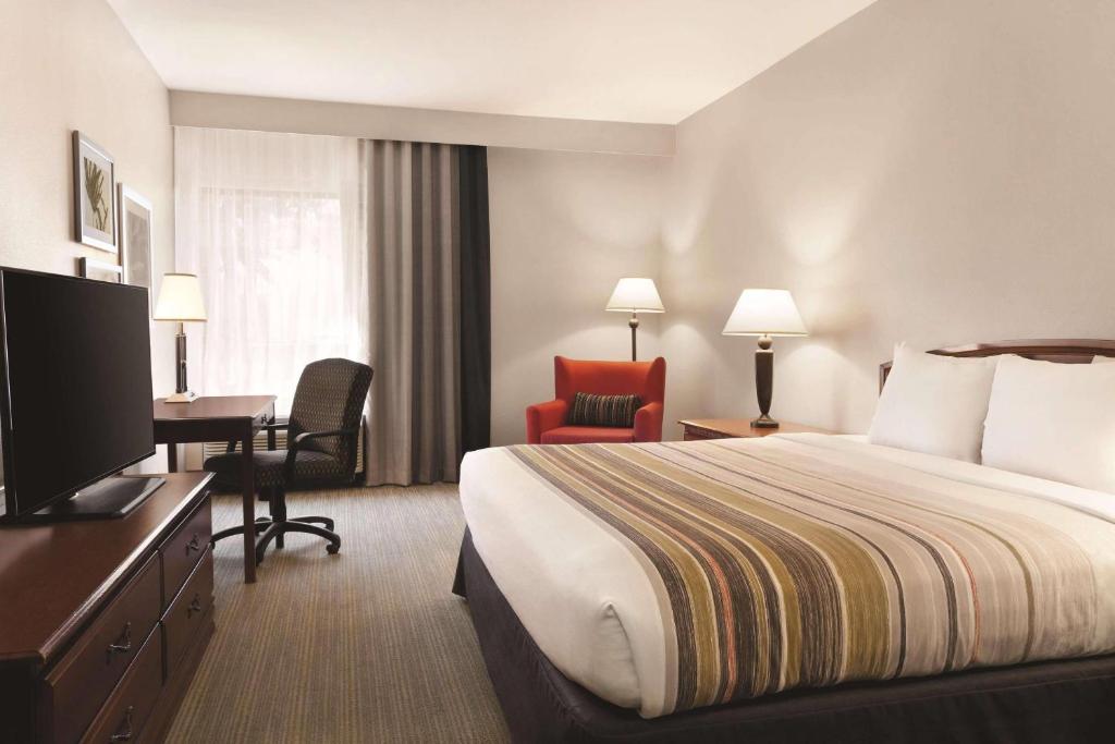 a hotel room with a bed and a desk and a television at Country Inn & Suites by Radisson, Bryant Little Rock , AR in Bryant