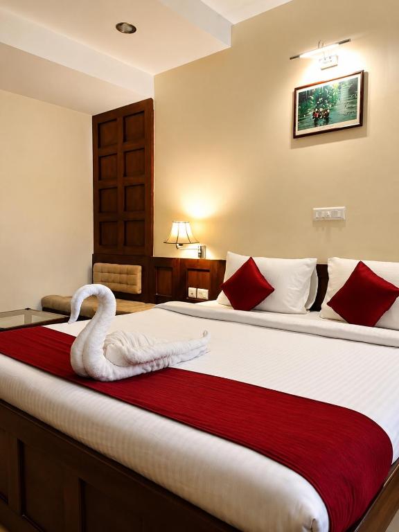 a bedroom with a large bed with a swan on it at Hotel Xavier's Avenue in Kadavoor