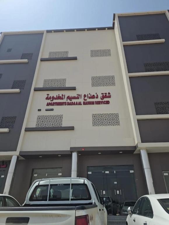 a building with cars parked in front of it at شقق ذاعذاع النسيم المخدومة in Al Khuraymī