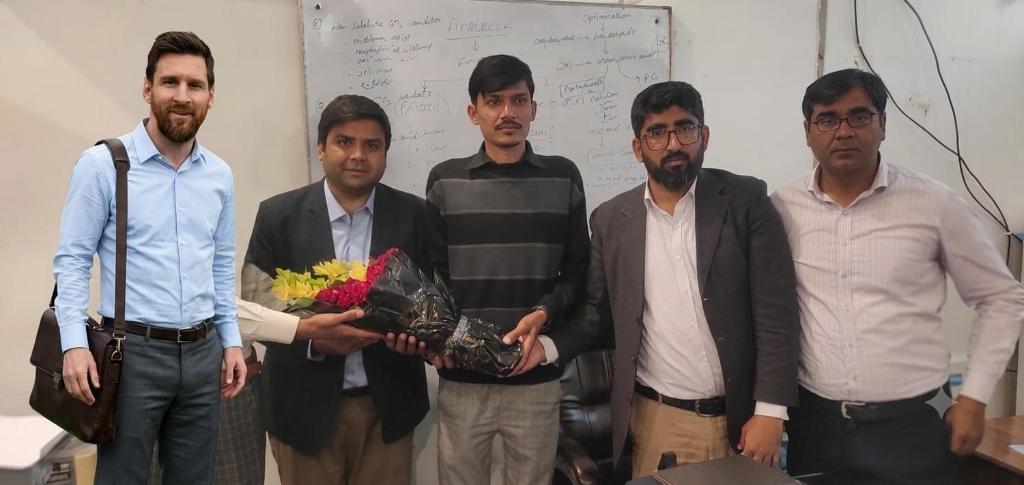 a group of men holding a bouquet of flowers at union flate in Faisalabad