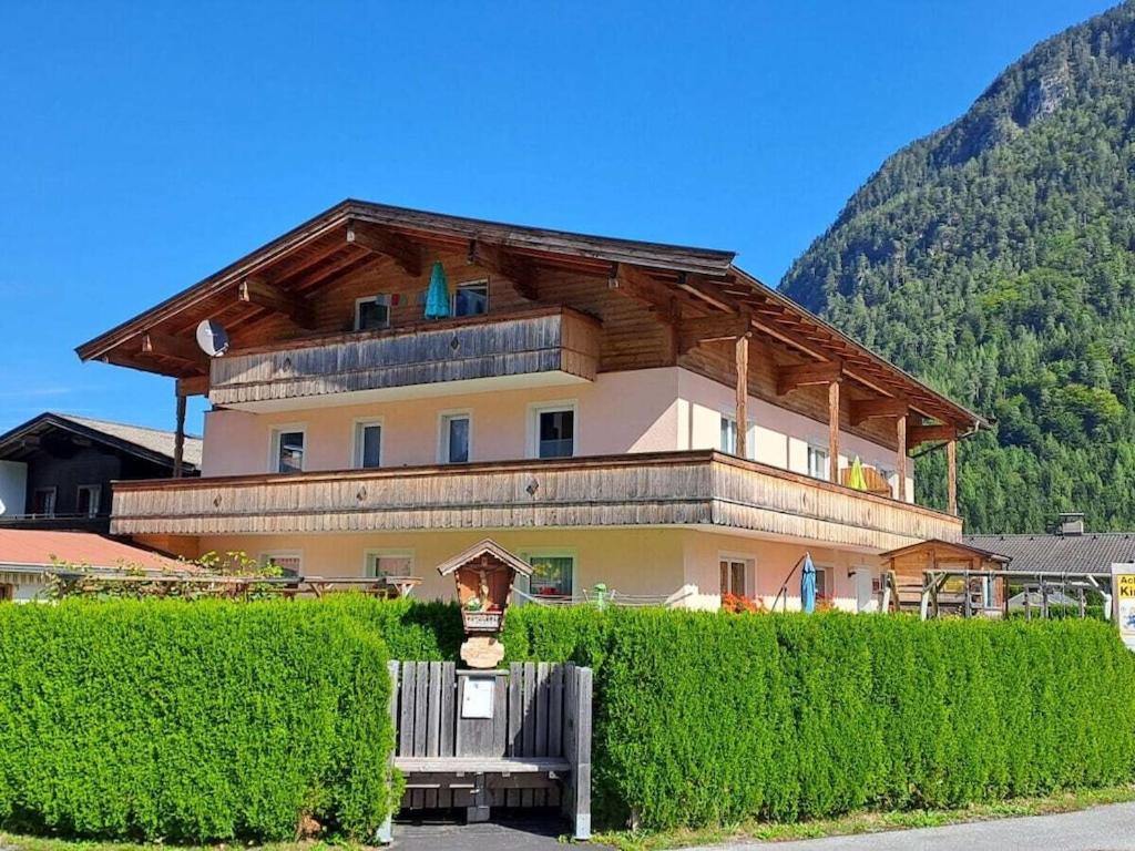 a large house with a wooden roof behind some bushes at Dürnberger in St Martin in Scheffsnoth