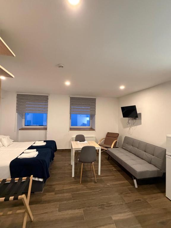 a room with a bed and a couch and a table at M70 Apartmanház in Miskolc
