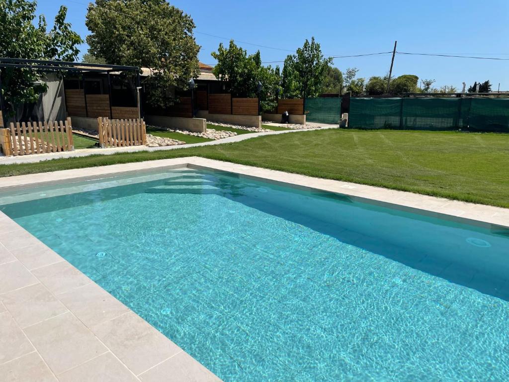 a swimming pool with blue water in a yard at Can Padrosa Mini loft 3 in Riumors