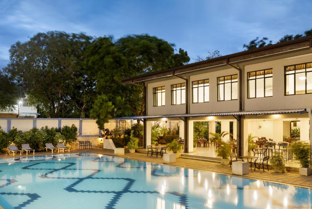 a large swimming pool in front of a building at Wave Hostels Arugam Bay - With Swimming Pool in Arugam Bay