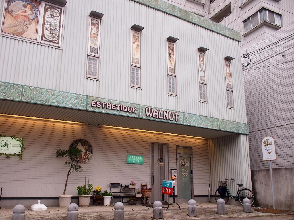 a white building with a sign that reads streetcar workshop at ゲストハウスノーチェ in Shingū