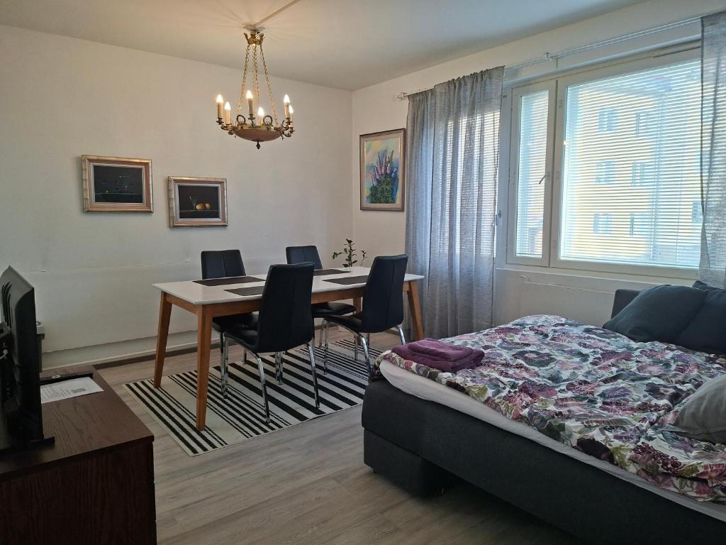 a bedroom with a bed and a table and chairs at City Apartment Hilla in Rovaniemi
