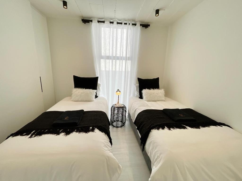 two twin beds in a room with a window at 42 on Kavango Unit 17 in Khomas Region