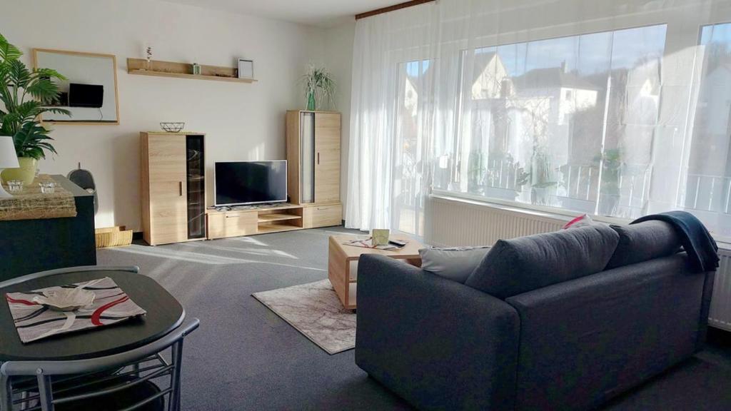 a living room with a couch and a tv at Nice Apartment mit Balkon in Glauburg in Glauburg