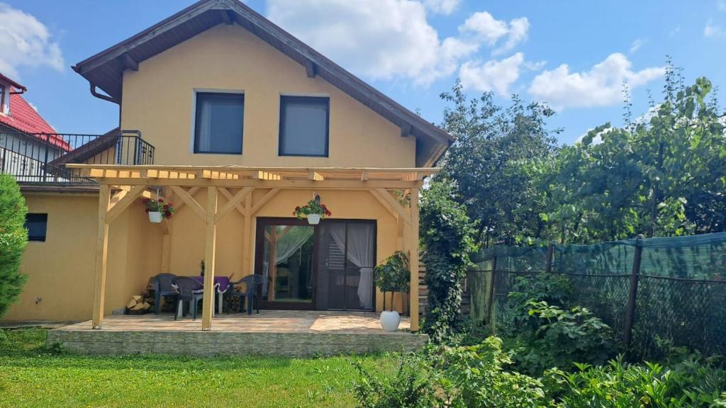 a house with a pergola on a patio at Casa Anna in Tîrnăveni